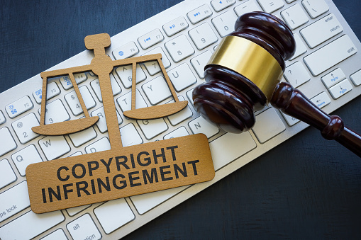 Copyright infringement phrase on the plate, a keyboard and gavel.