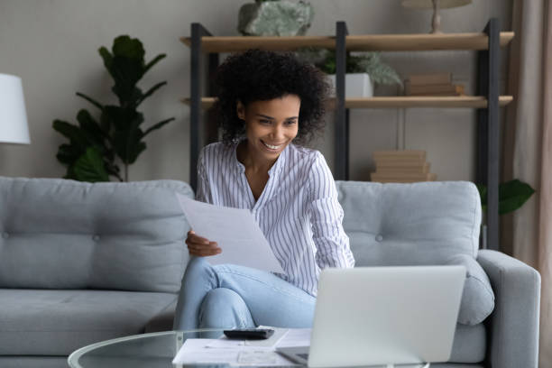 istock Smiling African American woman working with financial documents, using laptop 1425285777