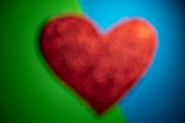 red defocused heart on green and blue background. color blur backdrop
