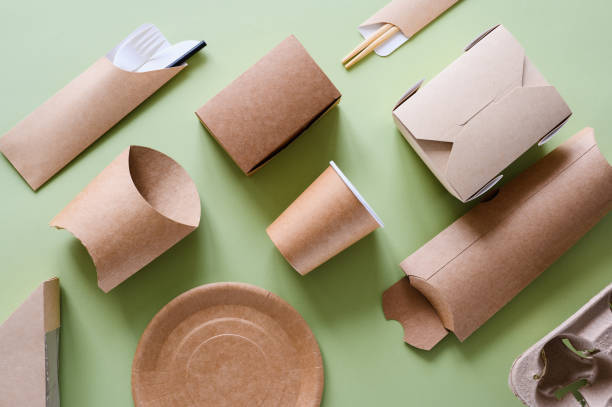 istock Smoothly stacked eco-friendly paper tableware on a green background. A set of items made from biodegradable materials to protect the world from debris. 1425286591