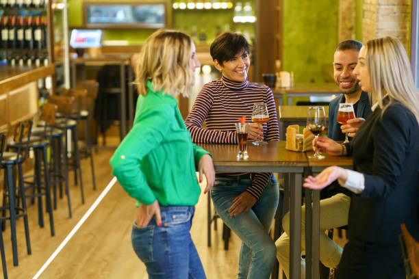 istock Blond woman speaking with friends in pub 1425289598