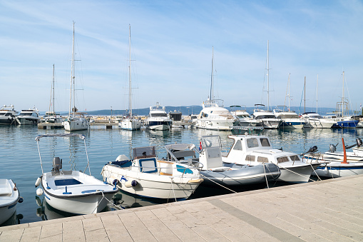 Sea harbor in Baska Voda. Yachts and boats are moored along the pier. Croatia. Adriatic Sea.
