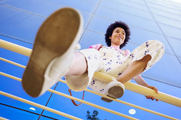 istock Optimistic black woman sitting on fence 1425289777