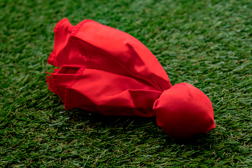 Red challenge flag thrown on the field concept for coach challenging the previous play and American football