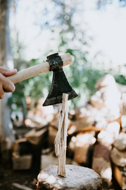 Strong man choping wood for the winter, with steel ax