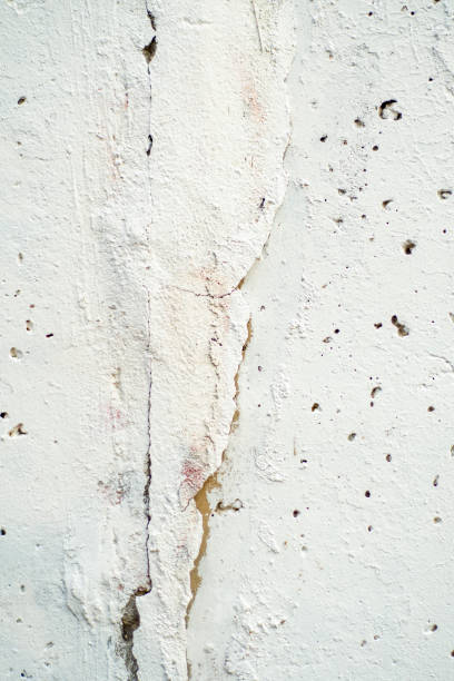 istock Background with a concrete wall messily painted with white paint. 1425291255