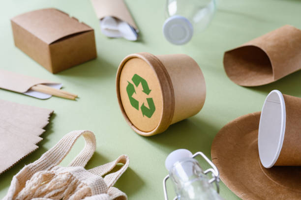 istock Recycling sign on a paper container for food. Various paper eco-friendly tableware. Selective focus on the container in the center of the frame. The concept of zero waste 1425291318