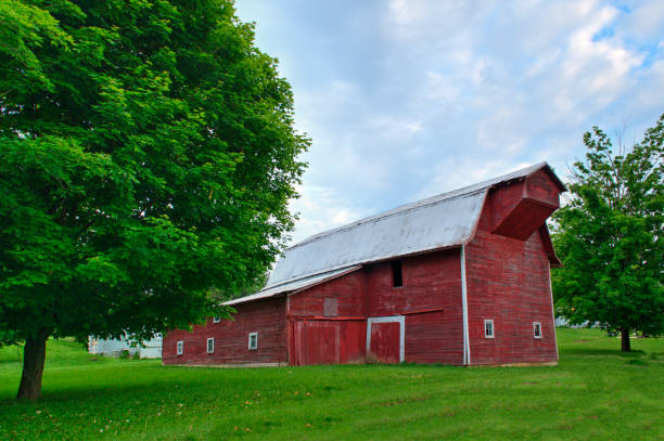 Red barn and out buildings on a farm in a field with two trees in Portland, Oregon, United States