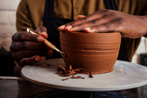 young and happy latino american businessman creating molds a handmade clay hands pot vase in workshop. sculptor creative studio workspace earthenware eco product