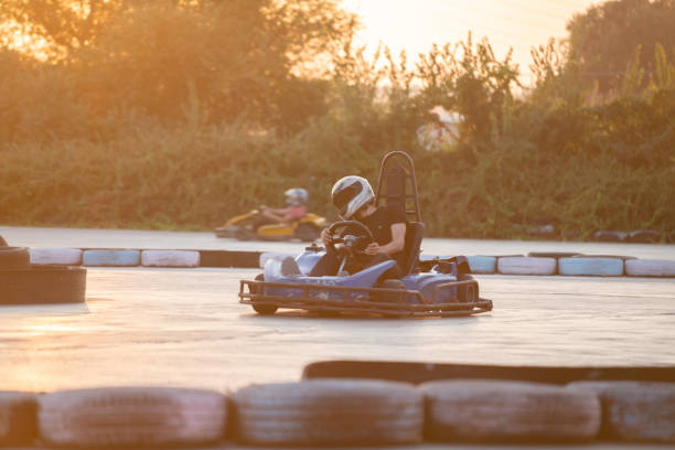 People driving a go-cart racing car on a racing track. Unrecognizable Caucasian male.