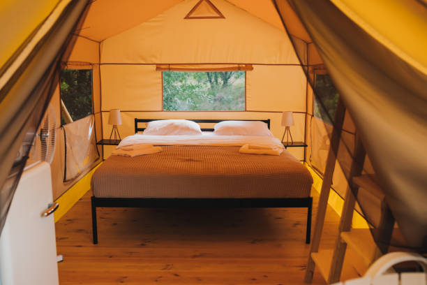 istock Interior of Cozy open glamping tent with light inside during dusk. Luxury camping tent for outdoor summer holiday and vacation. Lifestyle concept 1425295080