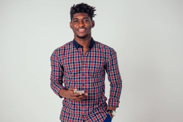 istock Afro american young holding phone in studio on white background 1425296000