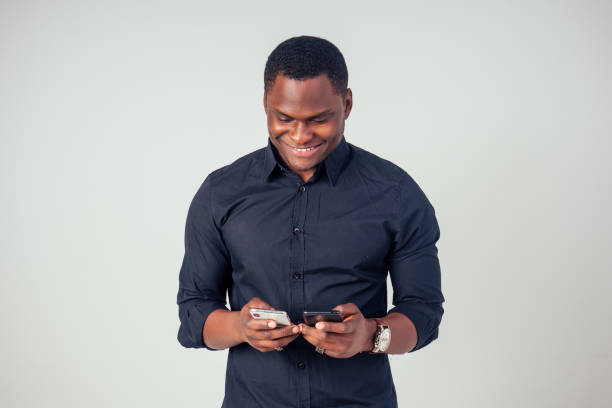 istock Afro american young holding phone in studio on white background 1425296005
