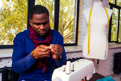 African American man working in a tailor workshop. fashion designer seamstress working on his atelier