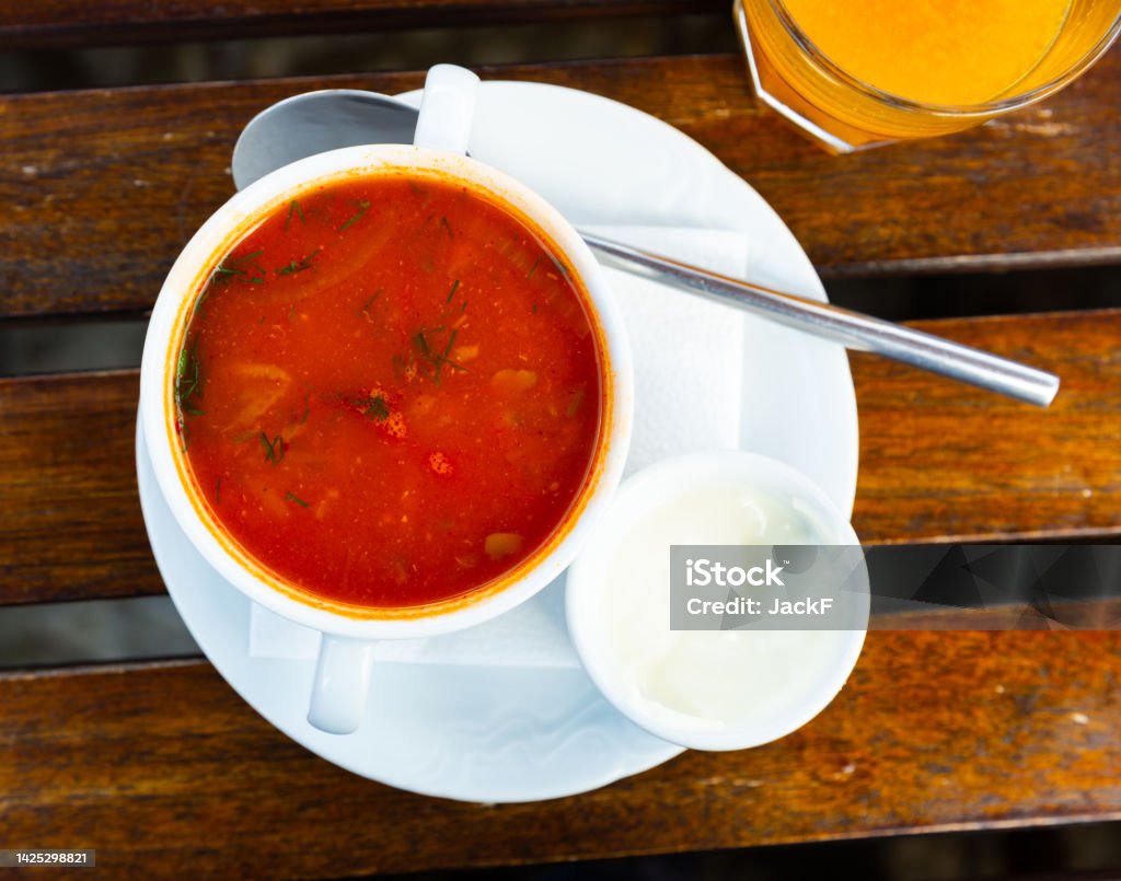Ceramic bowl with hodgepodge on a wooden table Appetizing vegetable soup hodgepodge, cooked in meat broth served in ceramic tureen Boiling Stock Photo