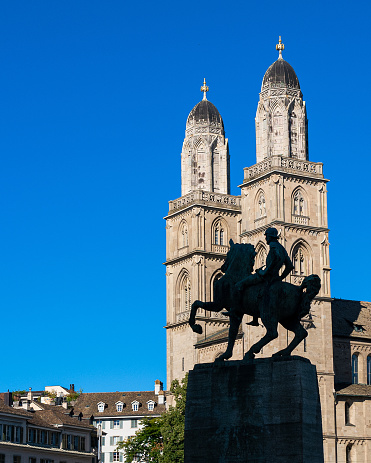 Silhouette of the Statue of Hans Waldmann at the foot of the Muenster bridge that crosses the Limmat river in old town Zurich. The Grossmuenster Cathedral in the background. Waldmann was once mayor of Zurich in Switzerland.