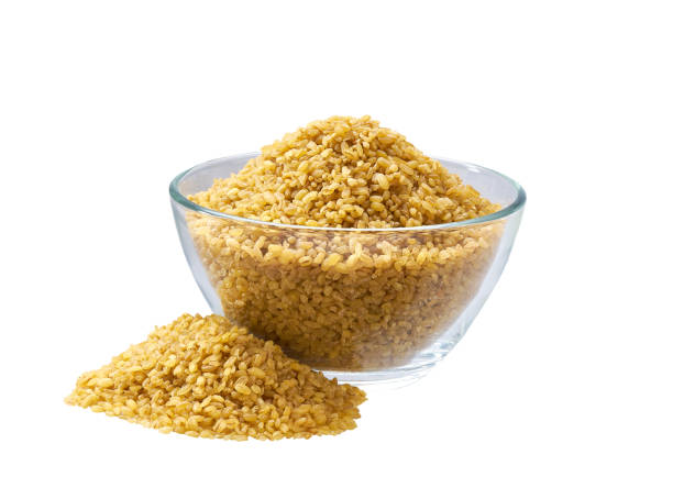 istock dry bulgur in a glass plate and scattered isolated on white background. 1425302329