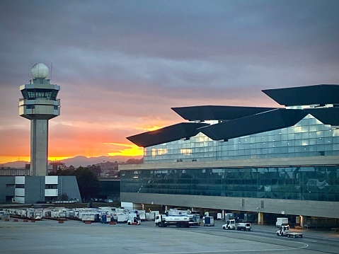 Internacional airport at Guarulhos, São Paulo, at sunset with a dramatic sky in background and the controllers tower and radar at the left