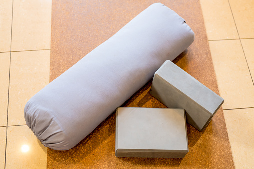 Yoga  bolster and yoga blocks all together on top of a yoga mat