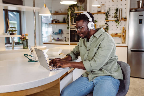 istock Young man concentrating on his work on a laptop at home 1425304348