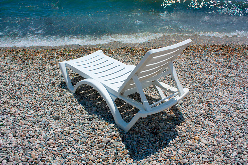 white chaise lounge on the beach in sunny day
