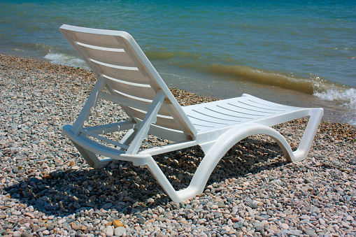 white chaise lounge on the beach in sunny day