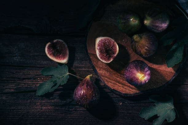 top down view on figs on a cutting board,   dark photography.