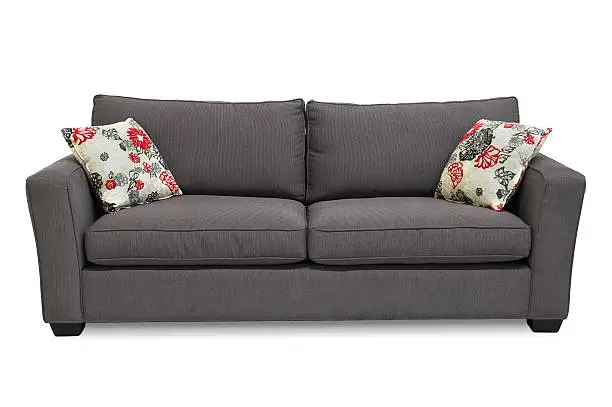 Two seat sofa / apartment sofa in grey upholstery accented with two pillows. Isolated on white.