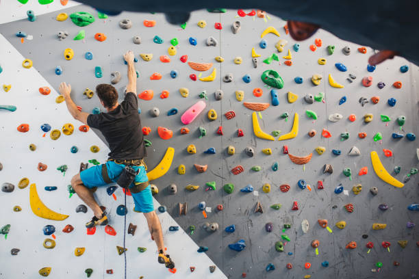 Athletic man climbing indoor wall. stock photo