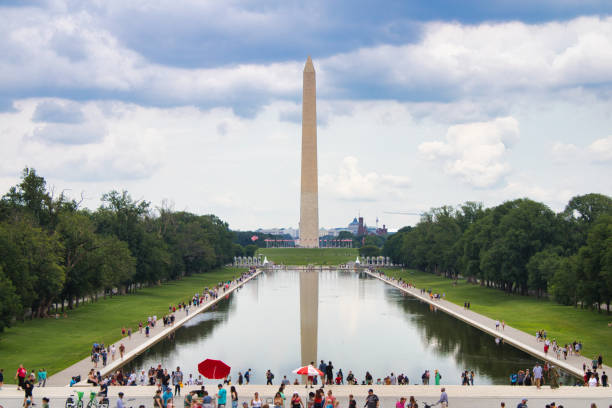 Washington Monument and Reflecting Pool on overcast summer afternoon Washington, D.C. - July 16th, 2022: Summertime view of the Washington Monument and Reflecting Pool from the base of the Lincoln Memorial washington monument reflecting pool stock pictures, royalty-free photos & images