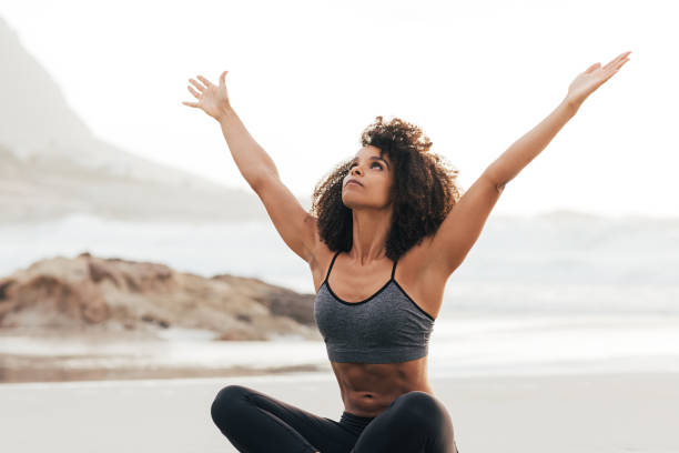 istock Young woman practicing Urdhva Hastasana yoga pose while sitting on a beach at sunset 1425311367