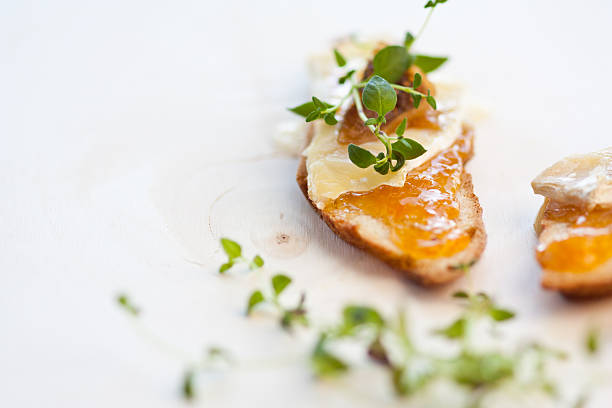 cheese and chutney crostini with thyme stock photo