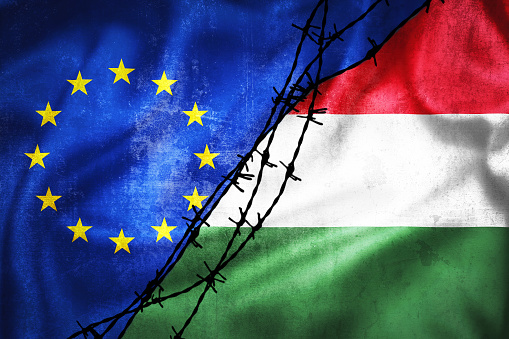 Grunge flags of EU and Hungary divided by barb wire illustration, concept of tense relations between and dispute of European union and Hungary