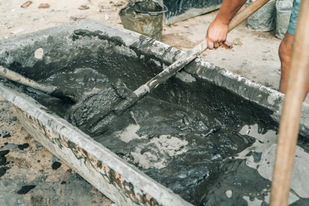 istock Workers stir or mix cement with shovels at construction site 1425313850
