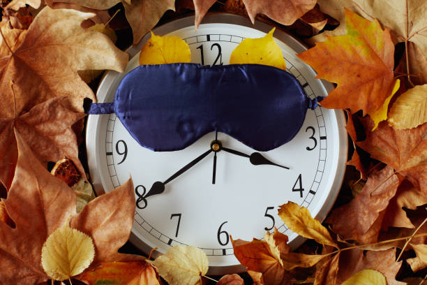 autumn flat lay with clock, sleeping mask and leaves