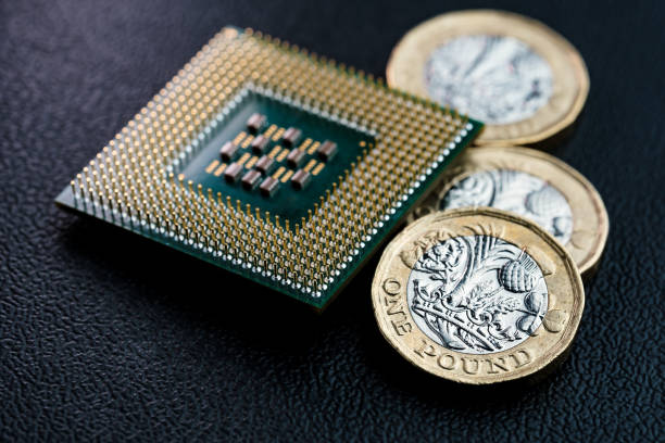 Large computer chip CPU and British pound coins. stock photo
