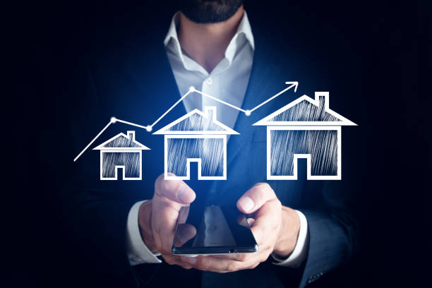 istock man holding phone with house models 1425319413