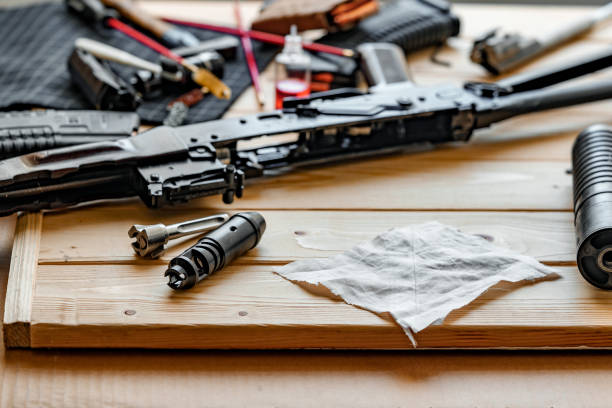 istock Black disassembled shotgun and cleaning tools on wooden table . 1425320126