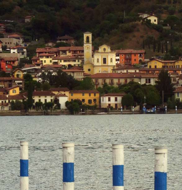 view across Lake Iseo at downtown Sale Marasino, Italy waterfront area, from Monitsola Island, with a boat dock in the foreground, Brescia, Lombardy