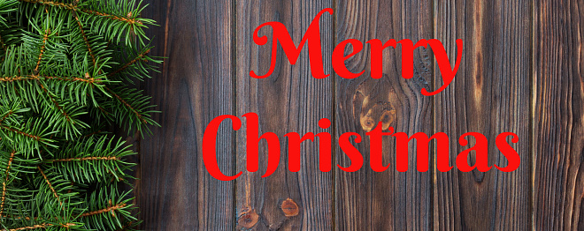 Merry Christmas text. Christmas fir tree on a wooden backgrond. Banner for advertising top view.