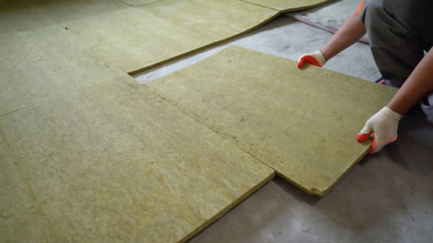 The builder insulates the floors of the house with glass wool. Laying glass wool on a concrete floor. stock photo