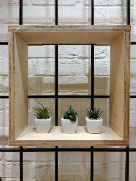 istock A decorative wooden square shelf with three flower pots hangs on a brick wall 1425335363