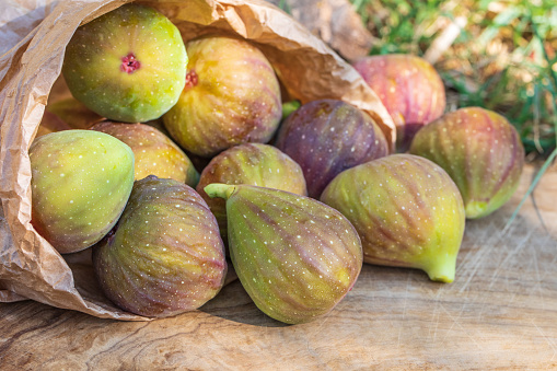 Raw sweet figs on a wooden background closeup. Red - purple e green figs. Organic gardening. High quality photo