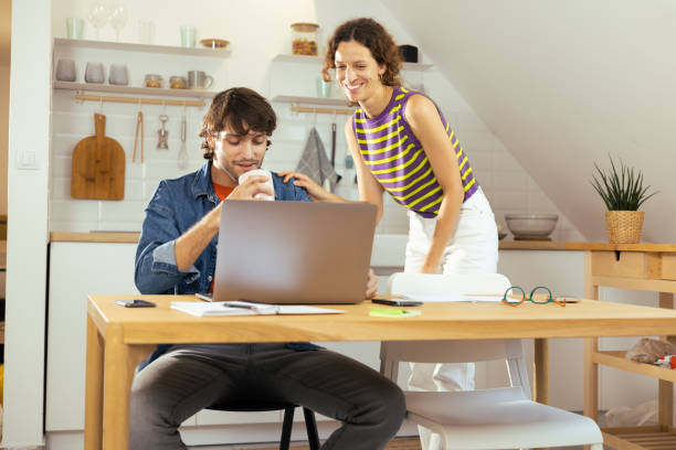 istock Smiling couple relaxing at home with laptop 1425338792