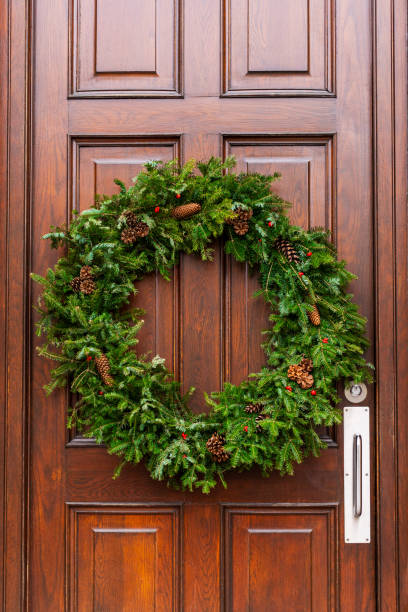istock Christmas wreath hanging on wooden front door. 1425338971
