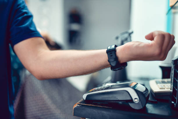 istock Male Paying In Barber Shop For Services Using Smartwatch And Credit Card Reader 1425339468