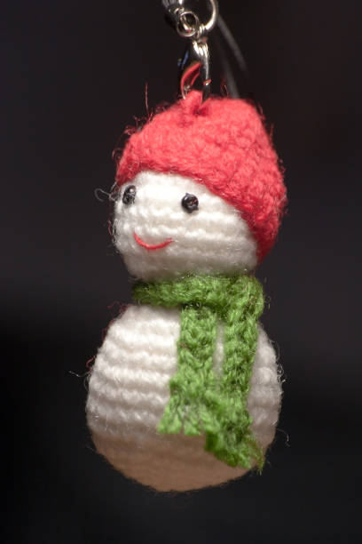istock Hand made key ring tiny snowman knitted doll wearing a red hat and green scarf 1425357756