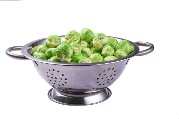 Fresh brussels sprouts in metal bowl isolated on white background.