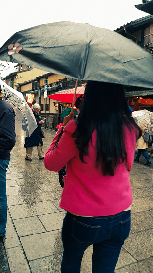 May 23, 2023 - Chuo City, Japan: Shoppers and travellers walk through Tsukiji Outer Market on a rainy morning.