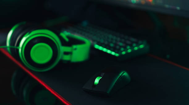 istock Gaming wireless accessories with green backlight next to headphones 1425367168